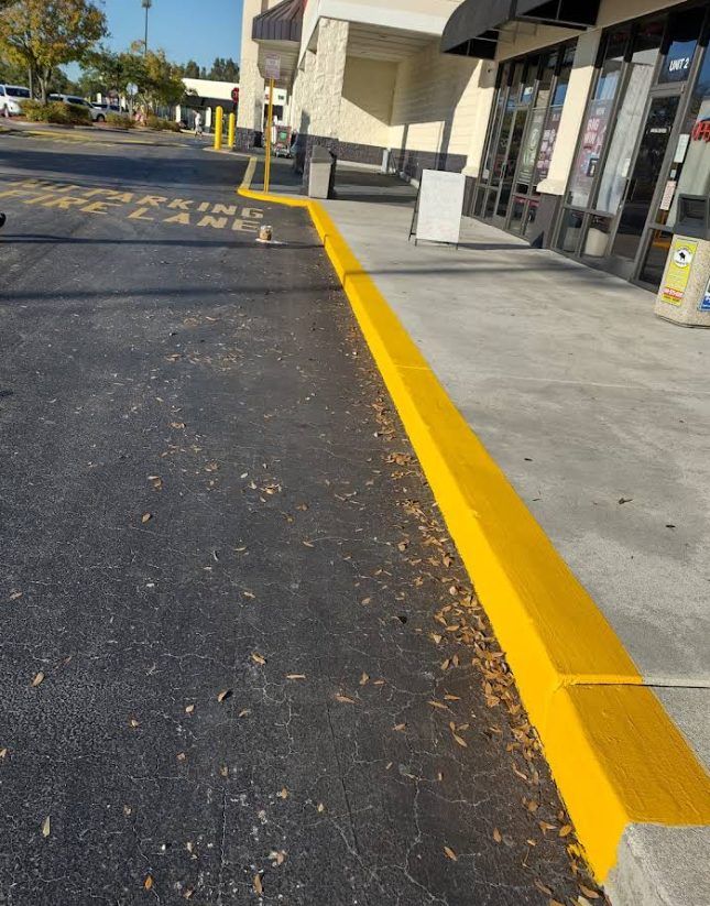 Freshly painted yellow curb along a shopping center fire lane